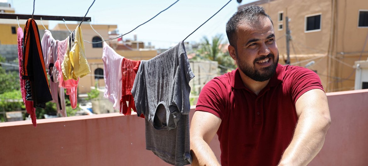 اللاجئ الفلسطيني، محمود شراري يساعد في الأعمال المنزلية في منزله في مخيم الرشيدية في لبنان.